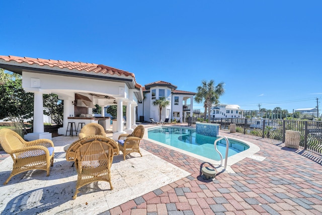 view of swimming pool with exterior bar, a gazebo, and a patio area