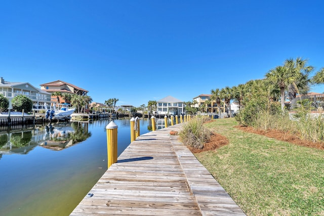 view of dock featuring a water view and a yard