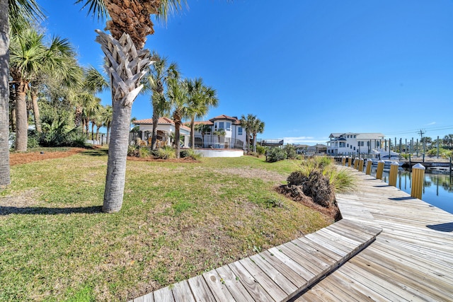 view of dock with a water view and a lawn