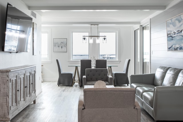 living room with light hardwood / wood-style flooring and an inviting chandelier