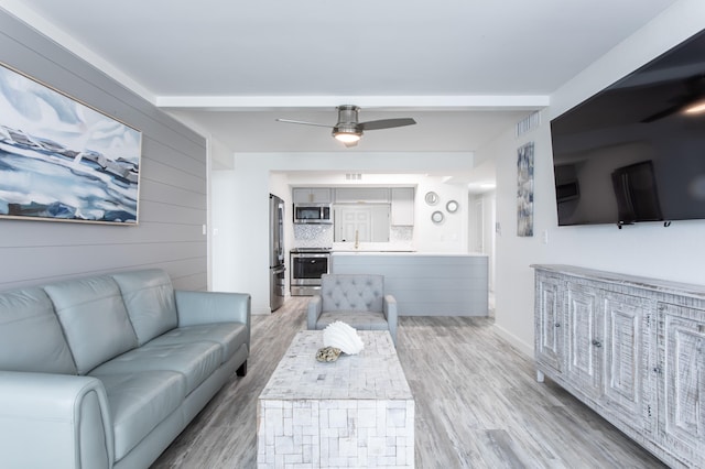 living room with sink, ceiling fan, and light hardwood / wood-style floors