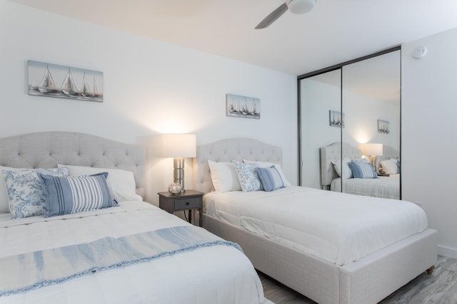 bedroom featuring wood-type flooring, ceiling fan, and a closet