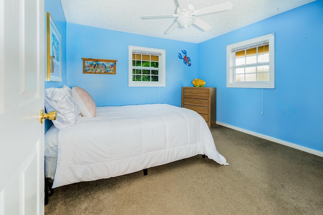 carpeted bedroom with ceiling fan and multiple windows