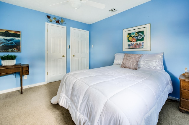 bedroom with ceiling fan, multiple closets, and carpet