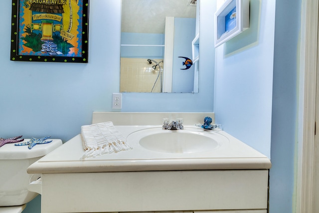 bathroom with a shower, vanity, and toilet