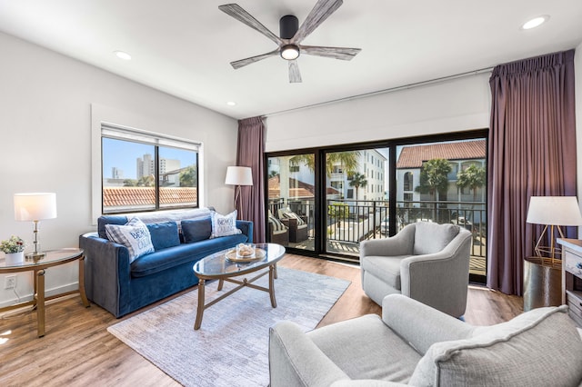 living room featuring ceiling fan and light hardwood / wood-style flooring