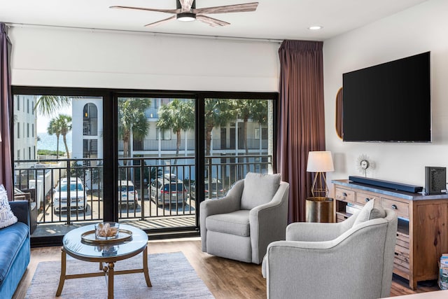 living room featuring light hardwood / wood-style floors and ceiling fan