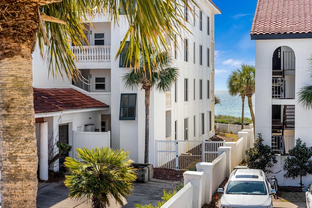 view of front of property featuring a balcony and a water view