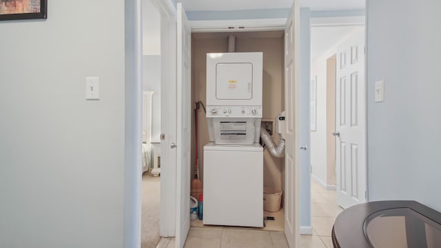 laundry room featuring stacked washer / dryer, laundry area, and light tile patterned floors