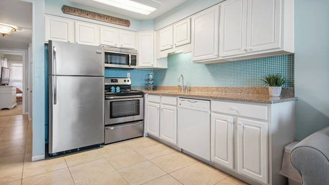 kitchen with white cabinetry, appliances with stainless steel finishes, tasteful backsplash, and a sink