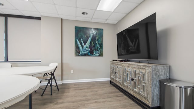 office area featuring wood finished floors, a paneled ceiling, and baseboards