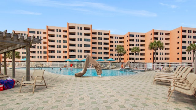 community pool with fence, a pergola, and a patio