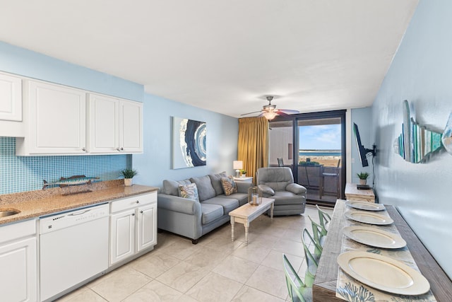 living area with a ceiling fan and light tile patterned floors