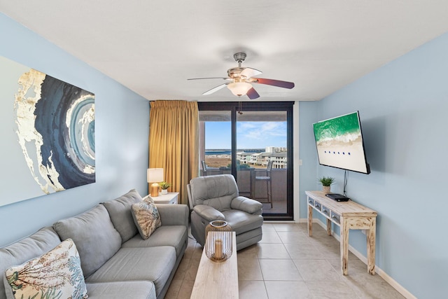 living room featuring ceiling fan, light tile patterned flooring, and baseboards