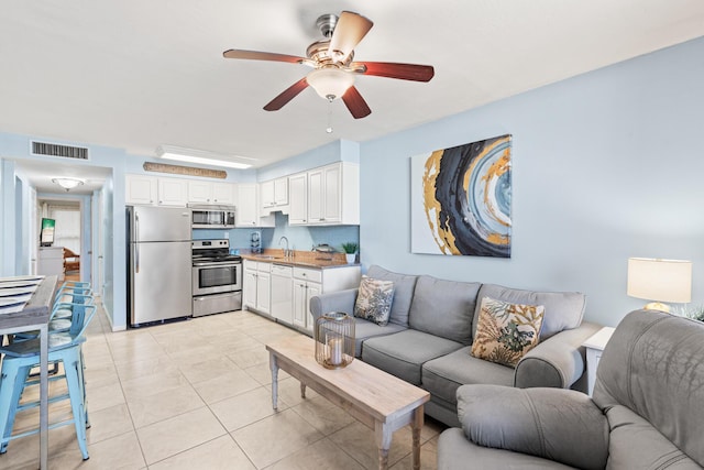 living room with visible vents, ceiling fan, and light tile patterned floors