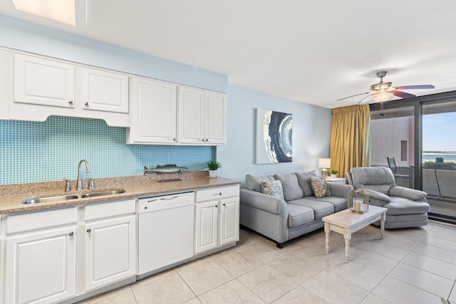 kitchen with white dishwasher, white cabinetry, open floor plan, and a sink