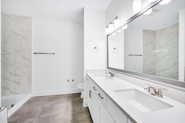 bathroom with tile floors, dual vanity, a shower with shower door, and toilet