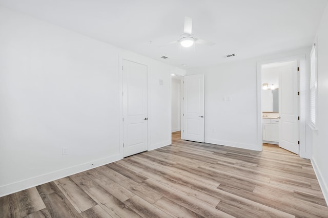 unfurnished bedroom featuring ensuite bathroom, ceiling fan, and light hardwood / wood-style flooring