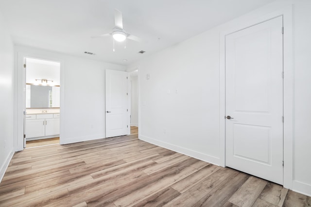 unfurnished bedroom featuring ceiling fan, connected bathroom, and light wood-type flooring