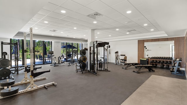 workout area with a raised ceiling and a drop ceiling