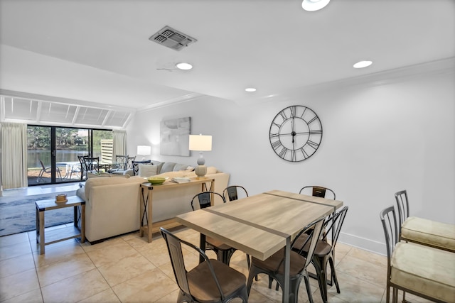 tiled dining room featuring ornamental molding