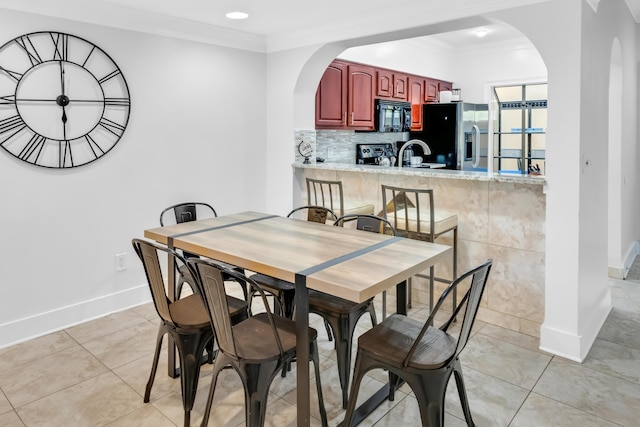 tiled dining area with sink and ornamental molding