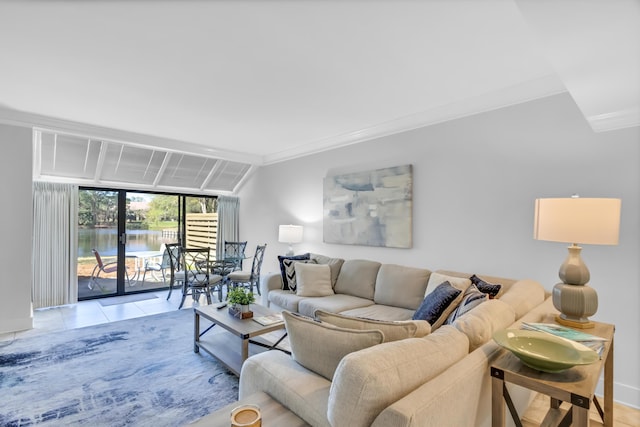 tiled living room with crown molding and a water view