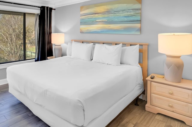 bedroom featuring hardwood / wood-style floors and ornamental molding