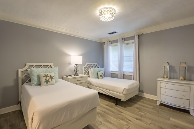 bedroom with light wood-type flooring and ornamental molding