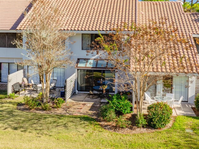 rear view of property featuring a yard and a patio