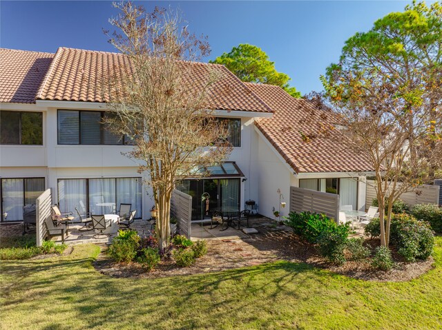 rear view of property with a lawn and a patio area