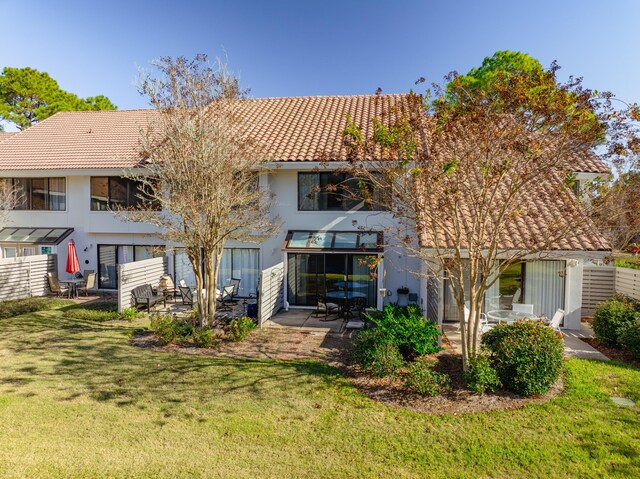 back of property with a patio and a lawn