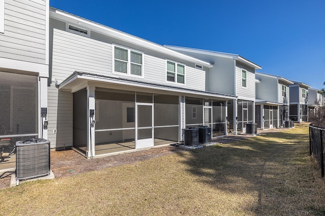 rear view of property featuring central AC, a sunroom, and a yard