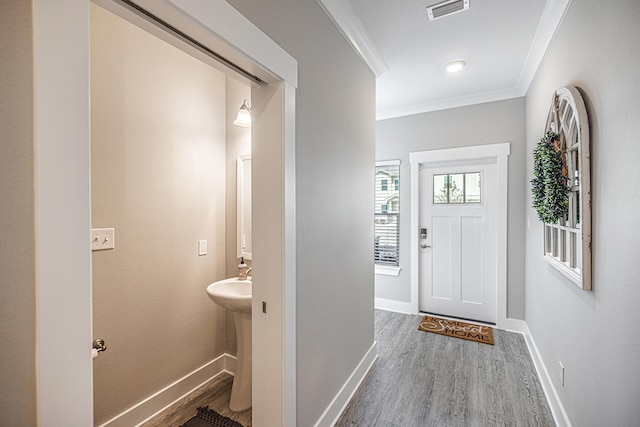 foyer entrance with ornamental molding and hardwood / wood-style flooring