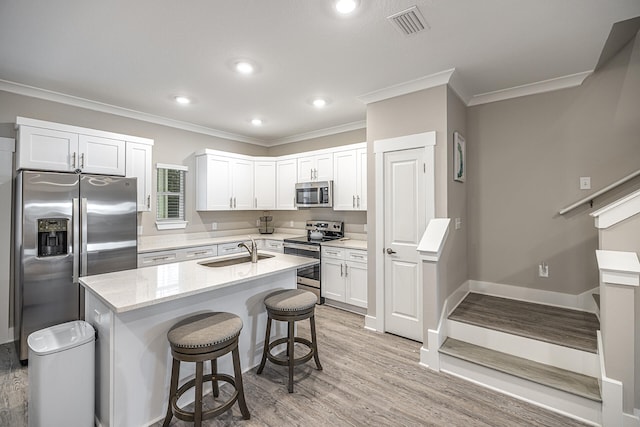 kitchen featuring a center island, light hardwood / wood-style floors, white cabinetry, stainless steel appliances, and sink