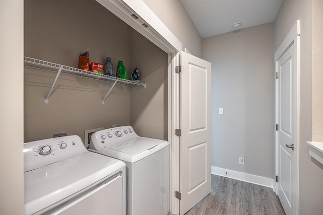 clothes washing area with washing machine and dryer, hookup for a washing machine, and light wood-type flooring