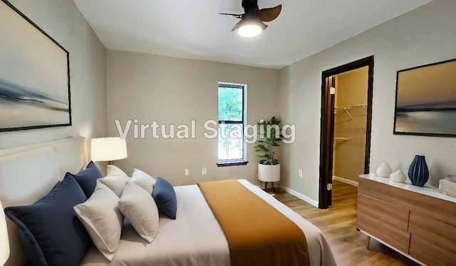 bedroom with a walk in closet and light hardwood / wood-style floors