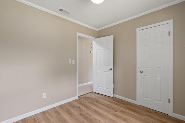 unfurnished bedroom with ornamental molding and light hardwood / wood-style flooring