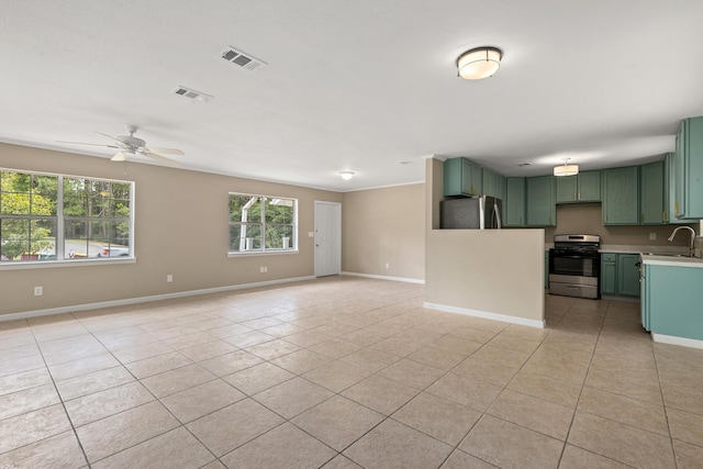 kitchen with sink, light tile patterned floors, appliances with stainless steel finishes, green cabinets, and ceiling fan