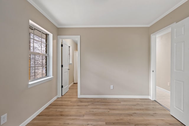 spare room featuring ornamental molding and light hardwood / wood-style floors