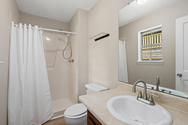 bathroom with vanity, curtained shower, and toilet