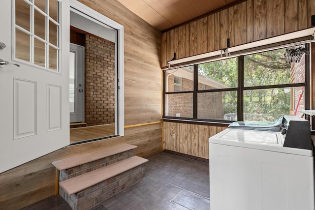 washroom featuring washing machine and clothes dryer, wood ceiling, and wood walls