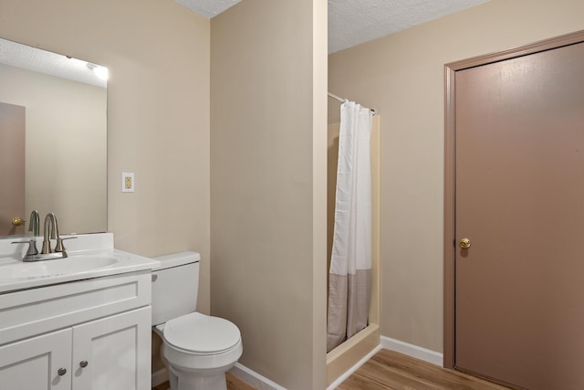 bathroom with vanity, curtained shower, a textured ceiling, and toilet