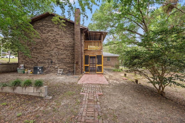 back of house featuring a balcony and cooling unit