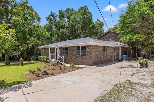 view of front of property with central AC and a front yard