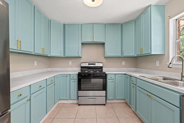 kitchen featuring stainless steel refrigerator, sink, range with gas cooktop, and light tile patterned floors