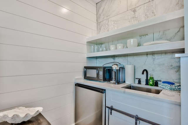 bar with sink, refrigerator, and white cabinetry