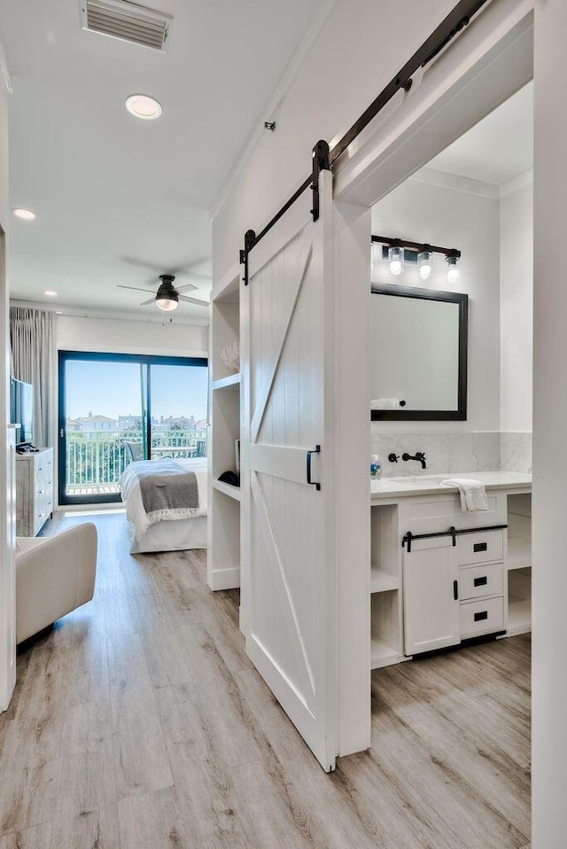 bathroom with wood-type flooring, ceiling fan, vanity, and crown molding