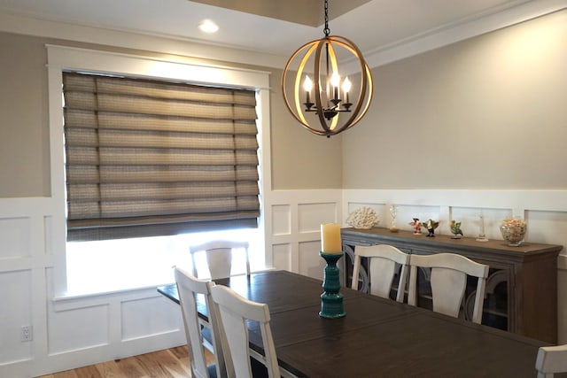 dining room featuring a decorative wall, recessed lighting, a notable chandelier, wainscoting, and light wood-type flooring