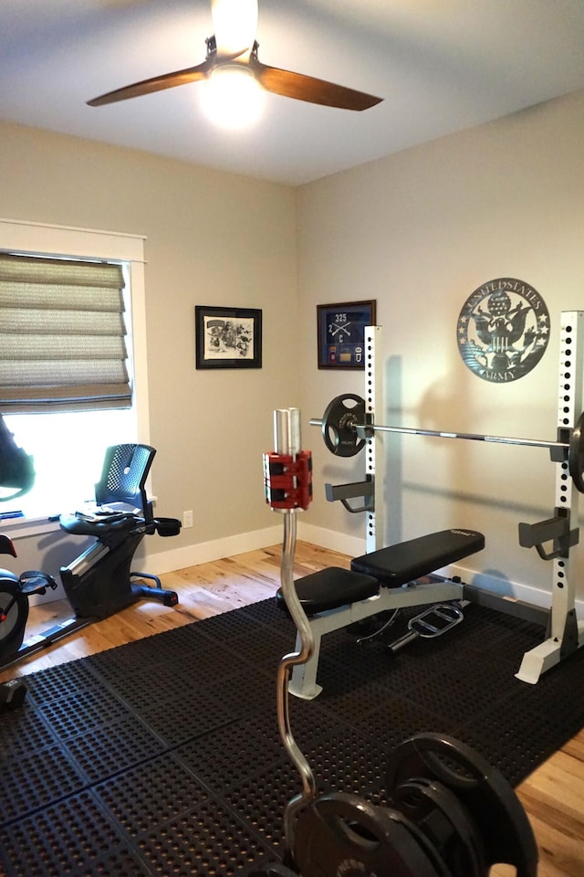 workout area featuring ceiling fan, baseboards, and wood finished floors